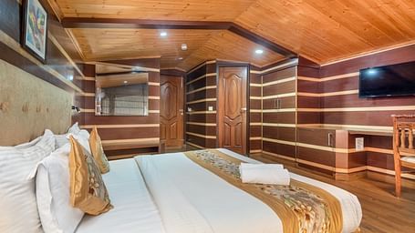 Super deluxe room featuring a king size bed and a wall-mounted TV at DLS Hotels The Rock Castle.
